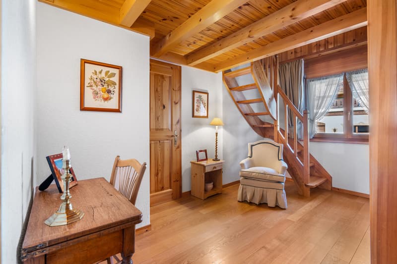 / a room with a wooden staircase, a desk and a chair on the second floor