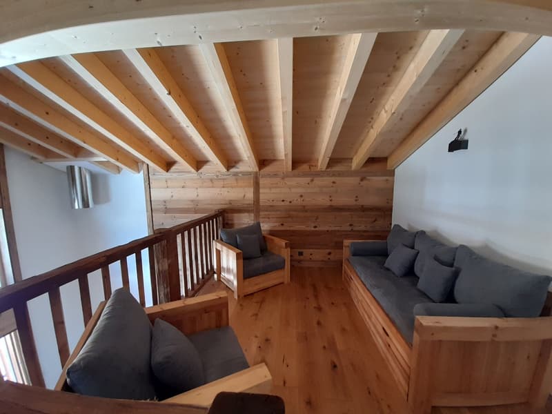 living area, wooden floor, wooden walls, gray sofas, wooden balcony railing, view from the balcony