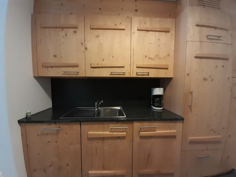 kitchenette, sink, stainless steel countertop, wooden cabinets, coffee machine