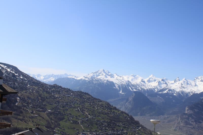 Mountain range with snow covered peaks, buildings, street lamp