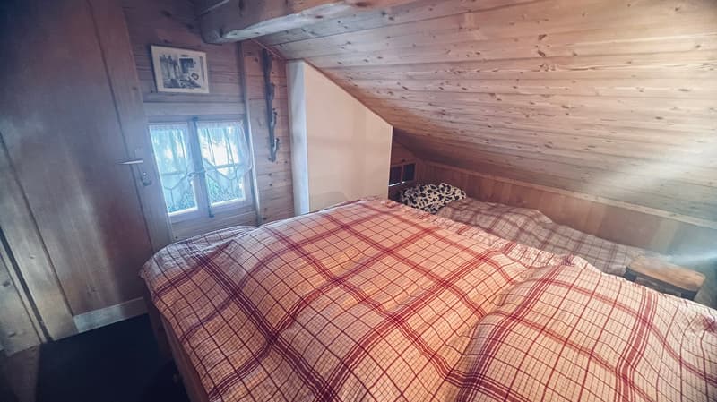 bedroom with two beds, wooden walls, window, wooden floor, wooden bed frame, wooden stool