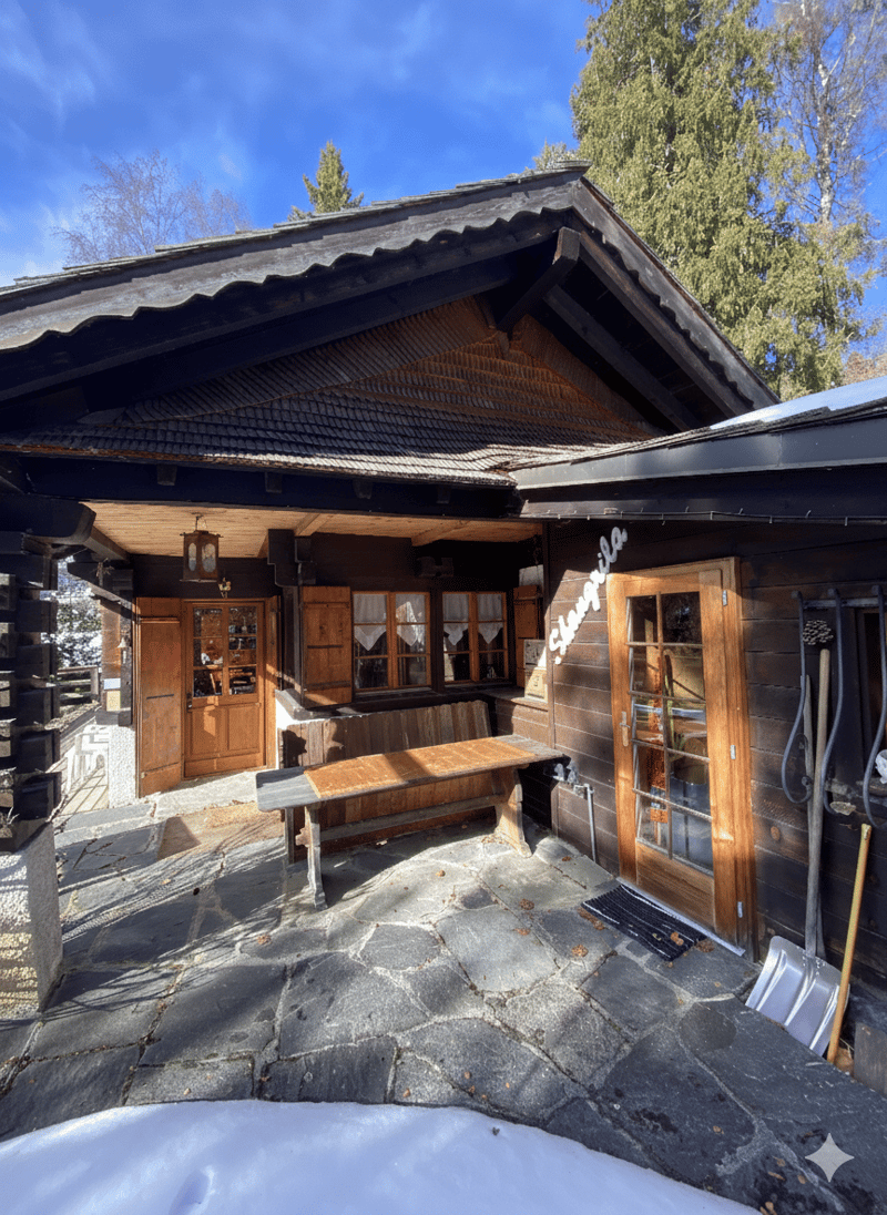 wooden house, raised ground floor, entrance with wooden door, wooden bench, lamp