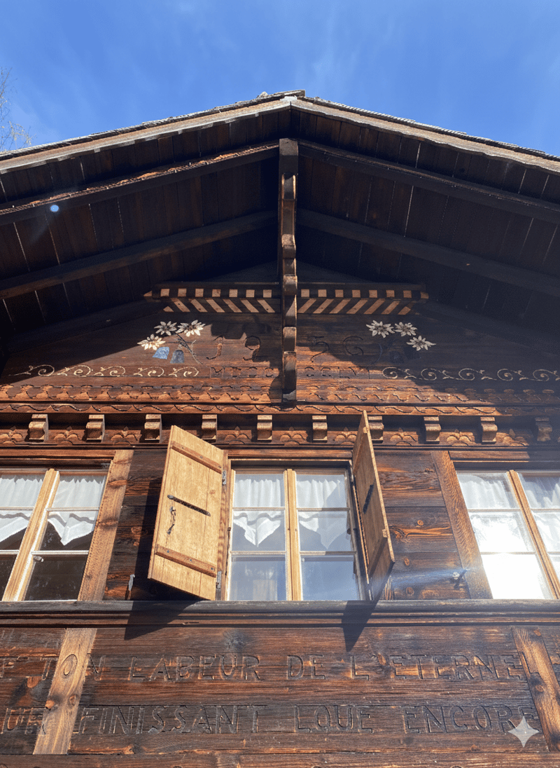 timbered house, wooden shingles, traditional design, French inscription, glass windows with white curtains