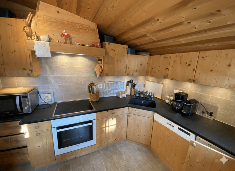 wooden cabinets, black countertops, electric stove, oven, microwave, sink, dishwasher, coffee maker, wooden ceiling