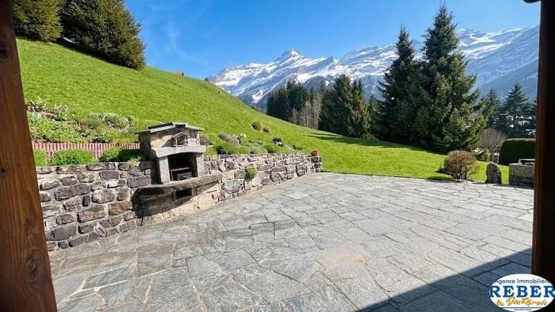 stone wall, stone patio, fireplace, green grass, trees, mountain view