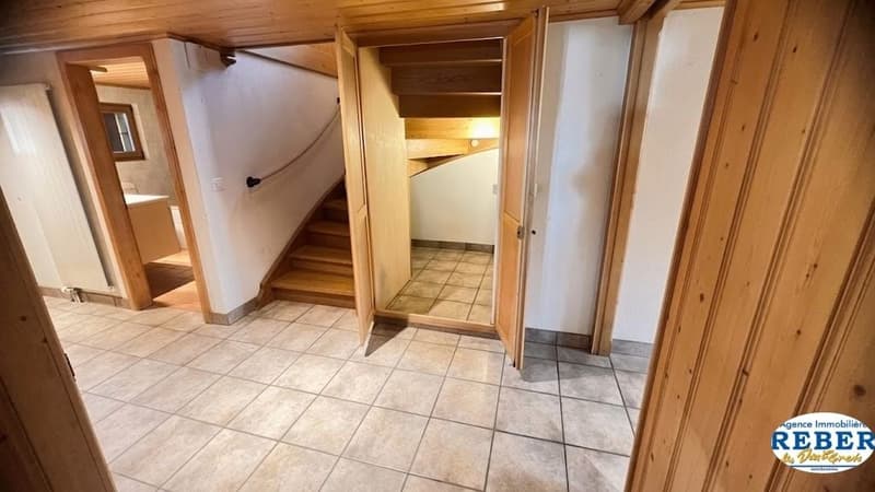 tiled floor, wooden doors, wooden staircase, white walls, radiator