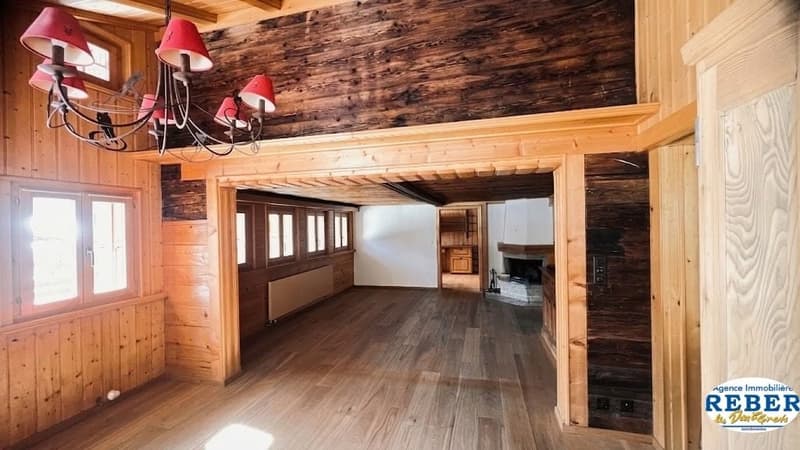 wooden walls, wooden floor, chandelier, fireplace, windows