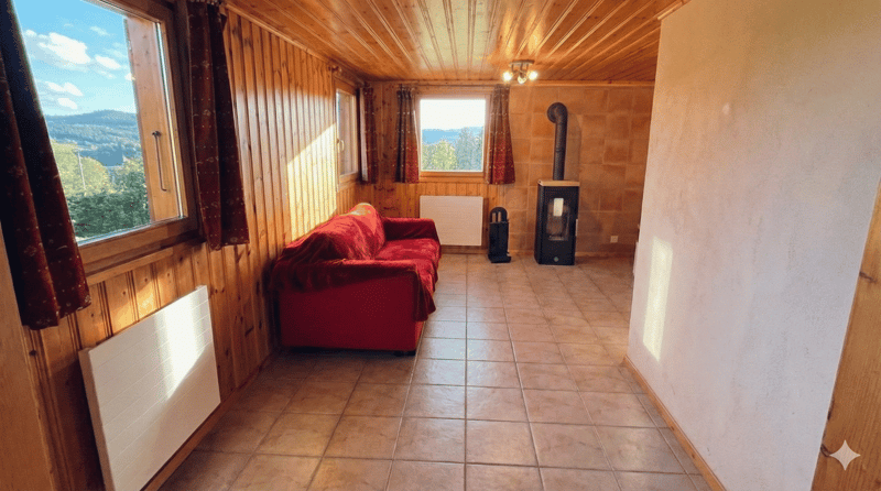 Red couch, fireplace, wooden walls, tiled floor, windows, radiators