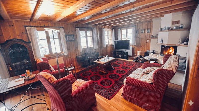wooden walls, fireplace, red carpet, red armchairs, wooden table, TV, shelves