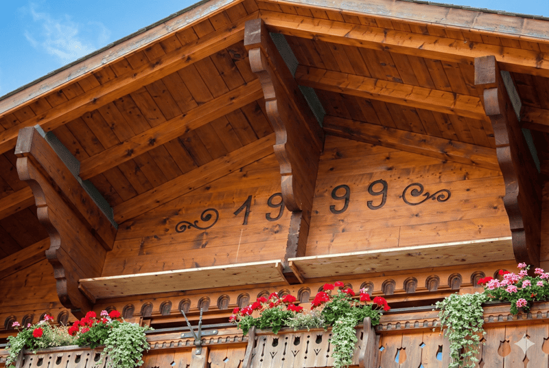 wooden exterior, balcony with flower boxes, year 1999 on the wall