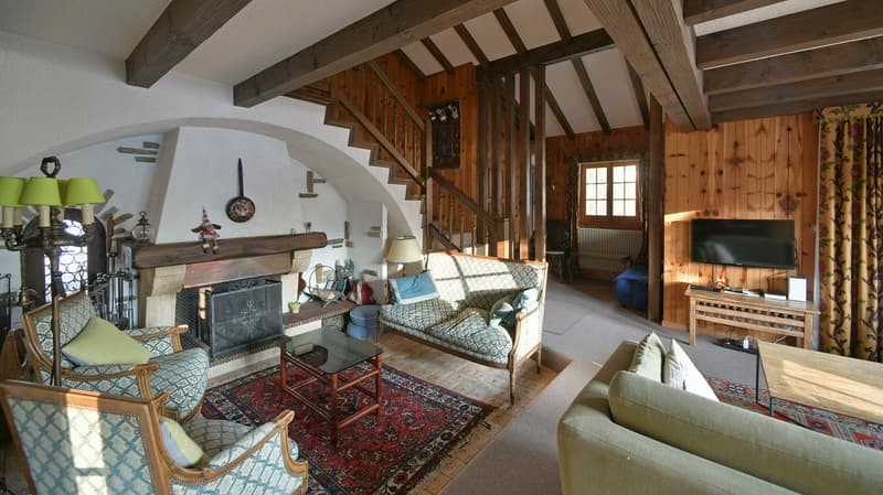 fireplace, wooden beams, blue and white couch, carpet, coffee table, TV, radiator