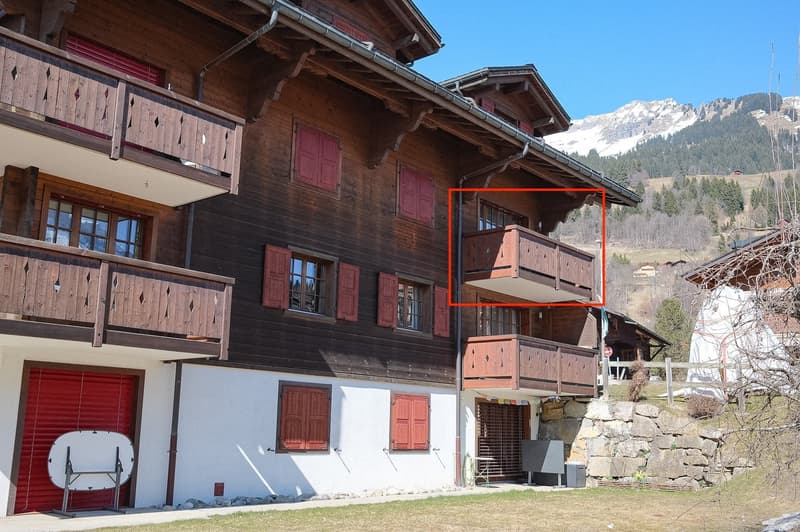 wooden exterior, red shutters, balconies, red garage door, mountains in the background
