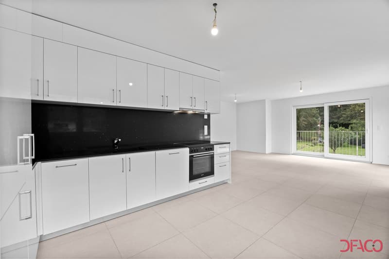 modern, sleek kitchen with white cabinets, black countertops, tiled floor, sliding glass door leading to balcony