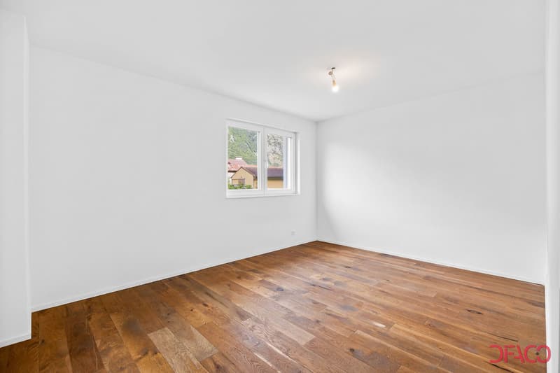 empty room with white walls, hardwood floor, single window with natural light