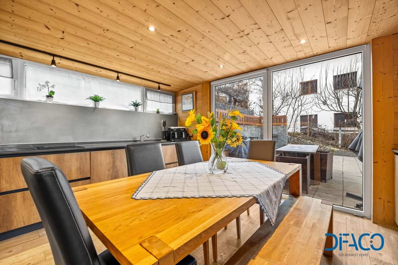 dining area with a wooden table, wooden benches, wooden cabinets, black chairs, gray ceiling with lights, windows, wooden floor