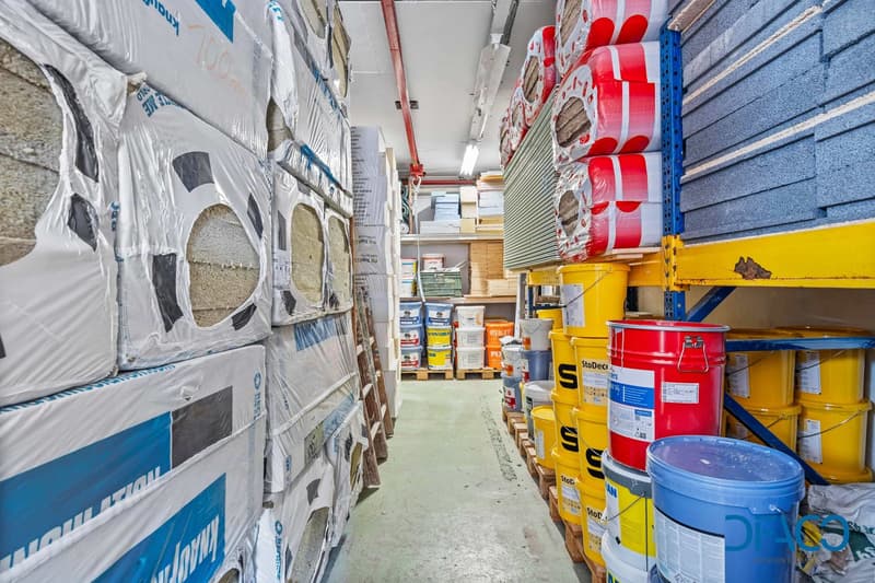 Warehouse with stacks of materials, buckets, and shelves