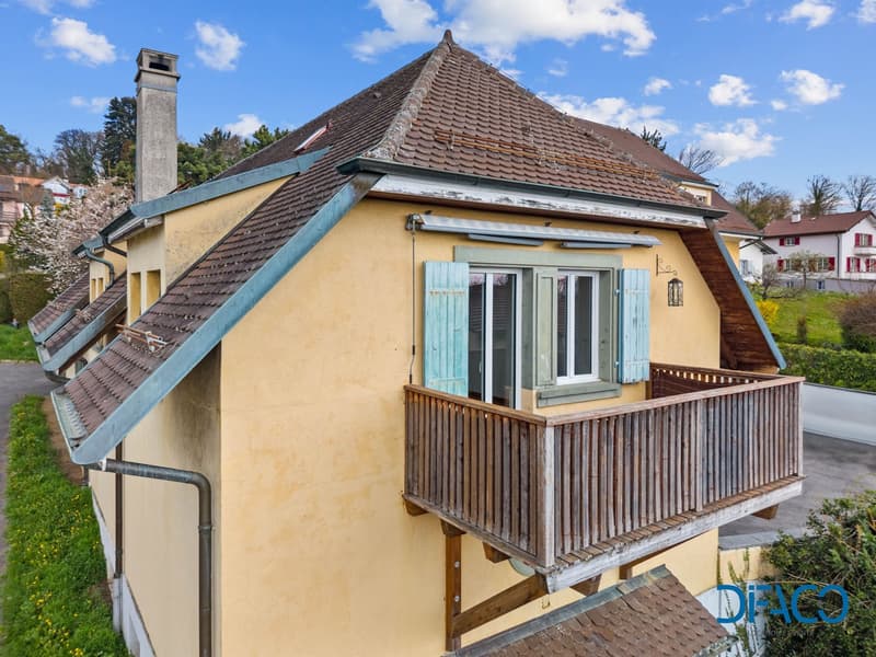 yellow house, brown roof, blue shutters, wooden balcony, chimney