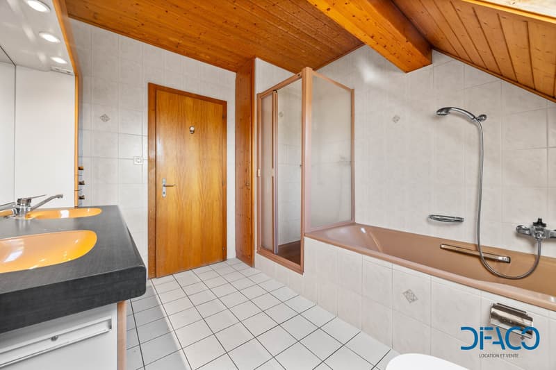 Bathroom with wooden ceiling, white tiles, double sink, shower, bathtub, wooden door