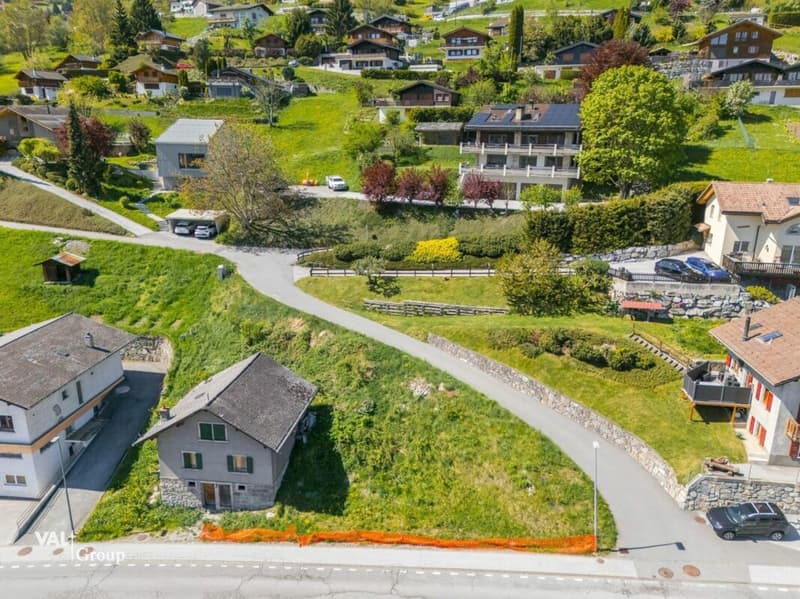Small houses with red brick roofs, white houses, driveway, street, and surrounding green grass.