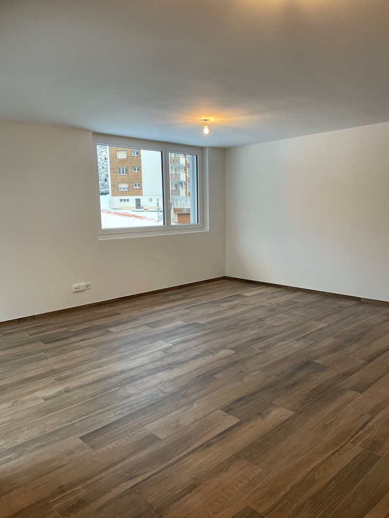 empty room, wooden floor, white walls, white window, electrical outlet on wall