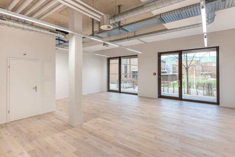 open room, hardwood floor, sliding glass doors, white walls, exposed ceiling beams