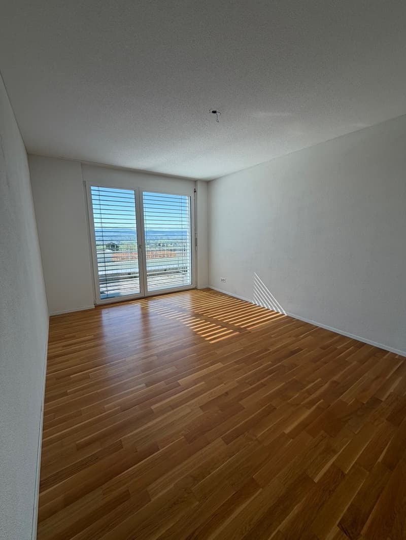 empty room, wooden floor, sliding glass doors, balcony, white walls, power outlet