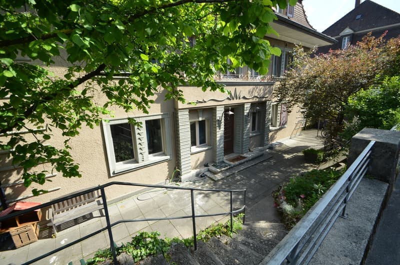 3 story house, beige exterior, white windows, raised ground floor, garden, stairs