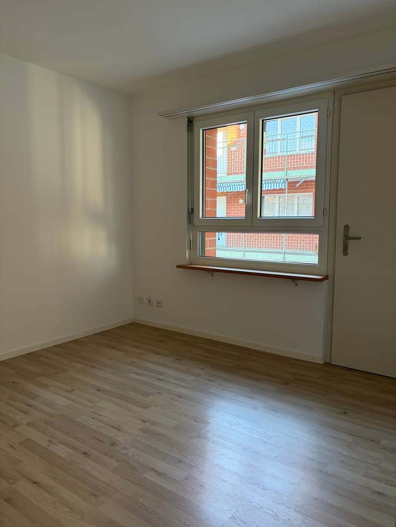 empty room, wooden floor, white walls, window with window sill, power outlets, door