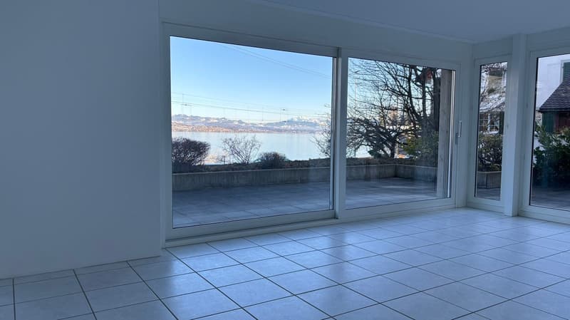 large glass doors, tile flooring, view of water and mountains