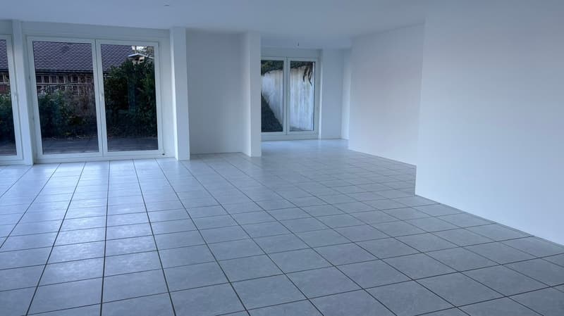 Empty room with sliding doors and balcony, white walls, tile flooring