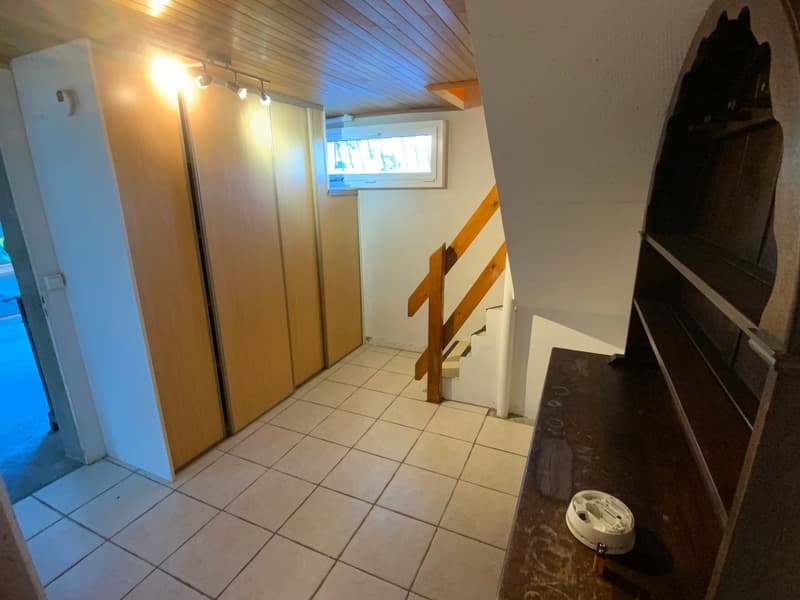 tiled floor, wooden wardrobe, wooden staircase, white ceiling, window on the side
