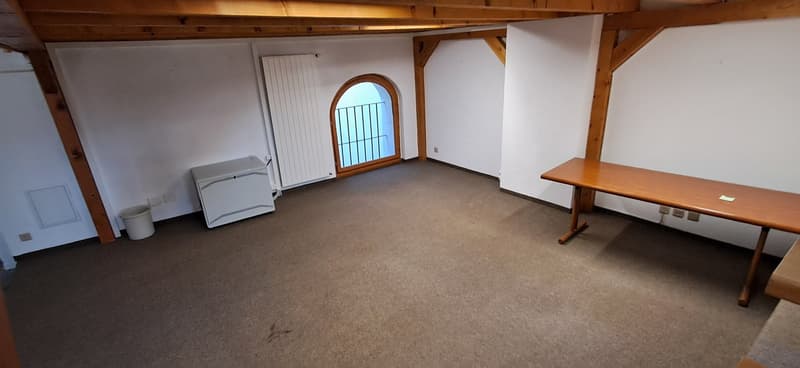 empty room, wooden table, white radiator, arched window, trash bin