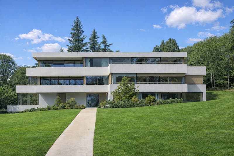 modern two story house, white and grey, concrete terrace, landscaped lawn, forest backdrop
