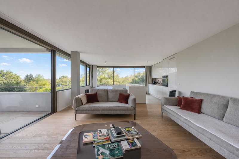 modern living room with large glass windows, 2 couches, round coffee table, wooden floor