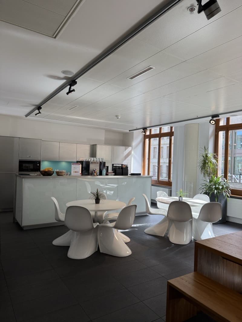 modern kitchen with white cabinets, central island, contemporary lighting, sleek furniture, minimalist decor, large windows, indoor plants, ample workspace, clean tiled floor