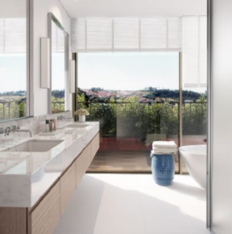 Spacious bathroom with large windows offering a scenic view, double vanity with white countertop, and a blue decorative item on the counter.