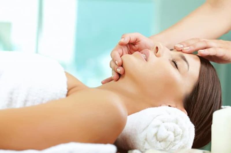 spa treatment being done on a woman, towel, candle