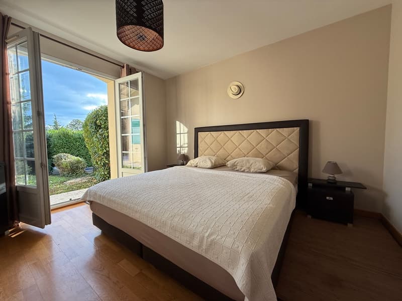 Double bed, white duvet, 2 pillows, bedside tables with lamps, open doors to a terrace
