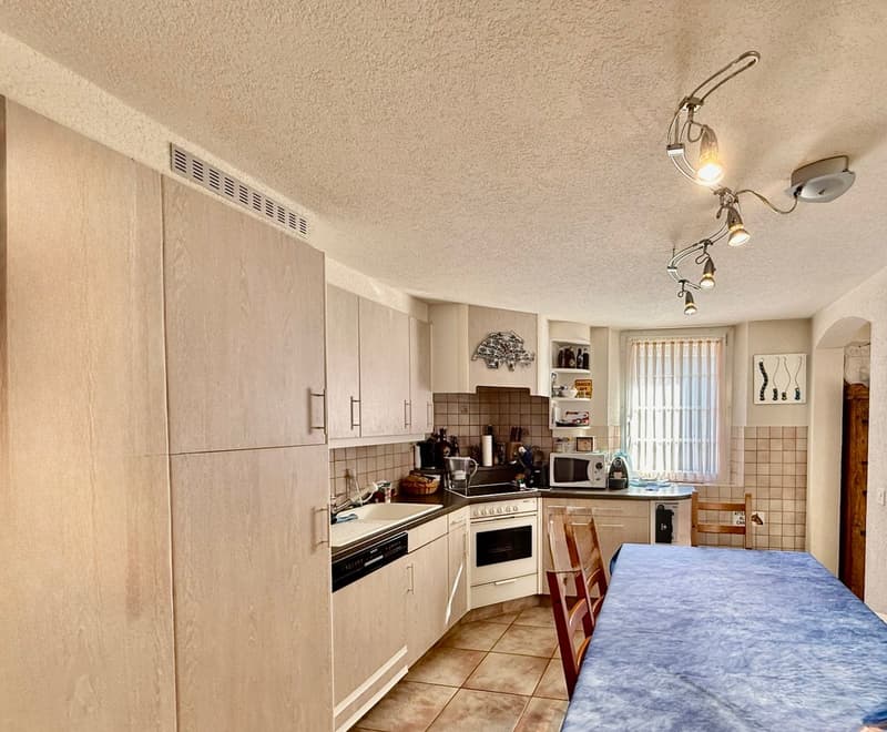 light kitchen with wooden cabinets, gas stove, dishwasher, washing machine, sink, microwave, windows