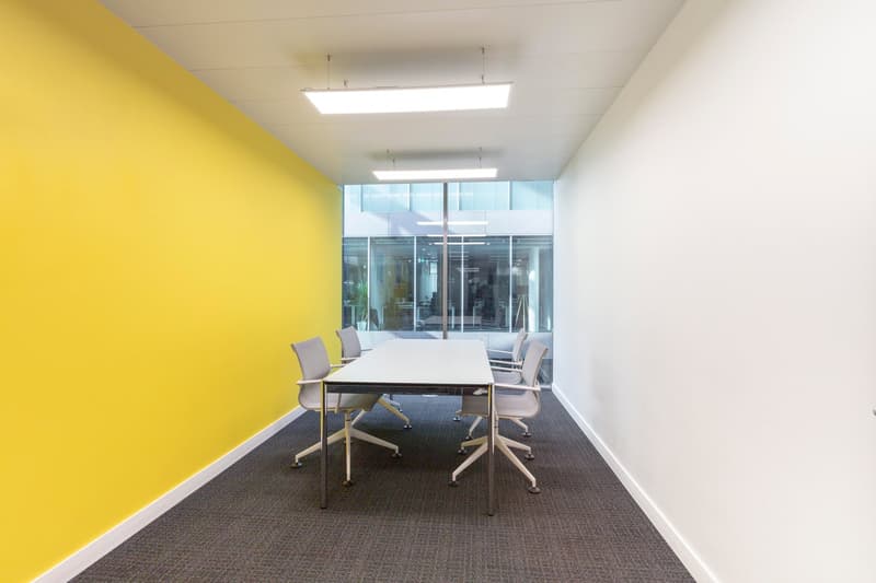 modern meeting room, large desk, chairs, yellow wall, glass wall, open space, minimalist design