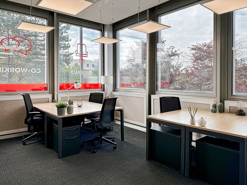 Open space office, 2 tables with 2 chairs, ceiling lamps, office desk lamps, black drawers, carpeted floor