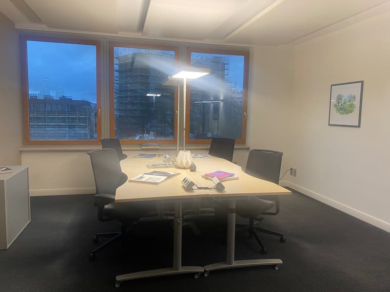 conference room with large windows, desk, chairs, lamp, picture frame, power outlet
