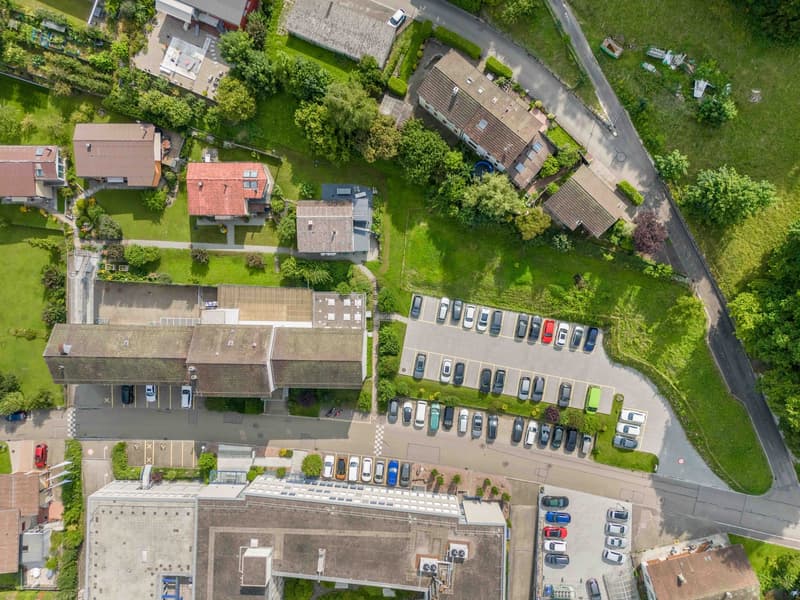 Residential area with multiple buildings and a parking lot.