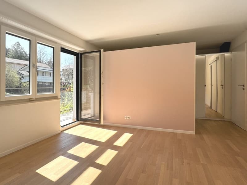empty room, wooden floors, sliding doors to balcony, large windows, light from the sun