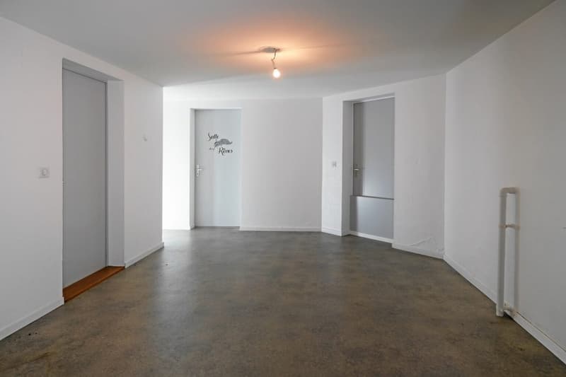 empty room, white walls, grey floor, three doors, writing on wall