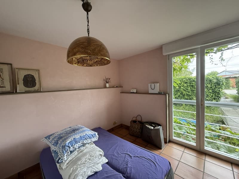Single bed, twin bed, pillows, blankets, pendant lamp, window, balcony, shelf with decorative items
