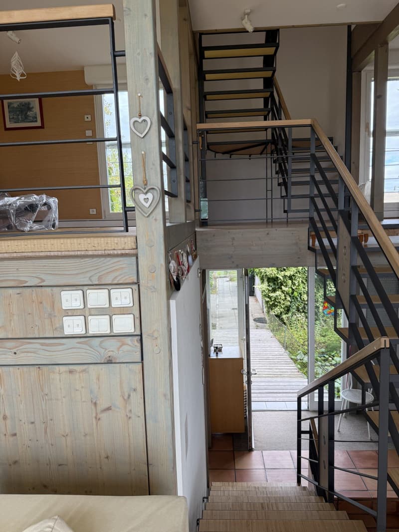 raised ground floor, wooden and metal staircase, wooden panels on walls, tiled floors, doors and windows
