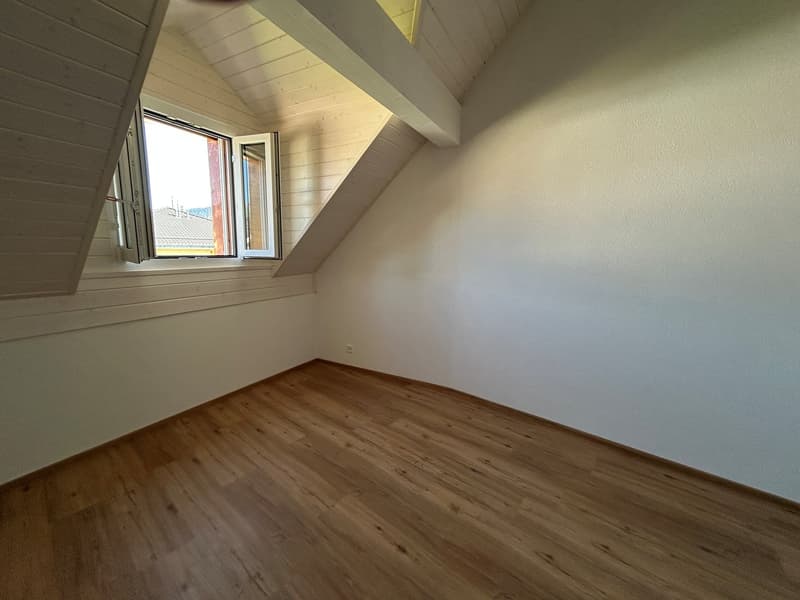 empty room, wooden floor, white walls, slanted ceiling, 2 windows, power outlet