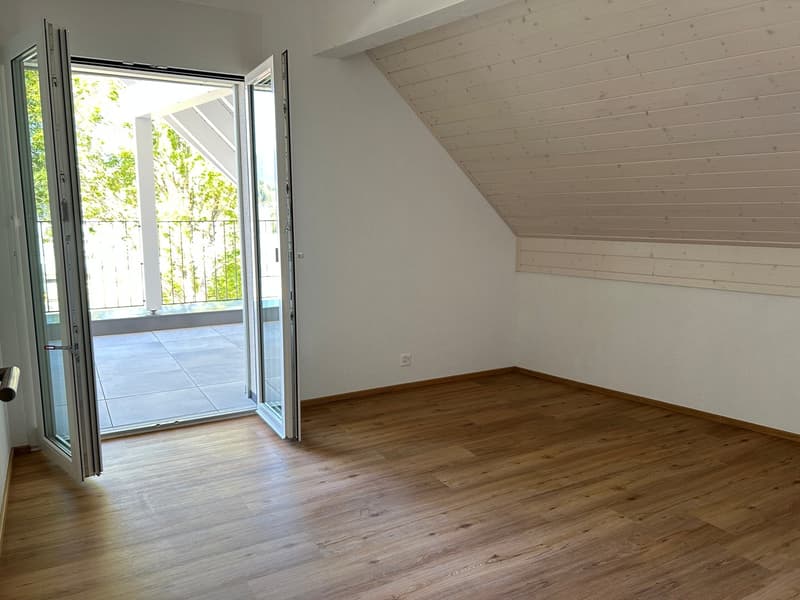 empty room, sliding doors, wooden floor, white walls, power outlet, slanted ceiling