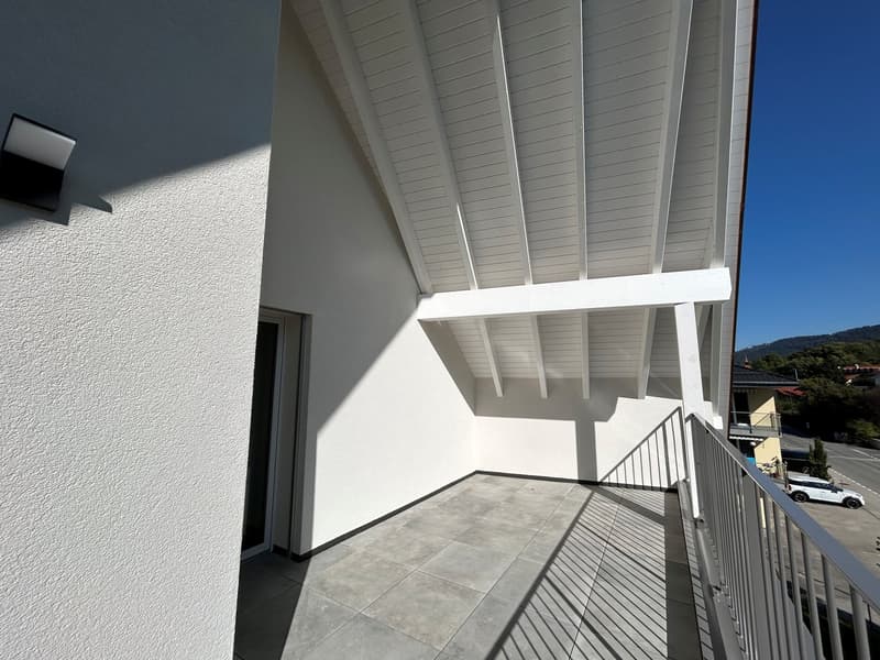 Empty balcony with white ceiling, railing, tiled floor, glass door, wall-mounted light, shadow